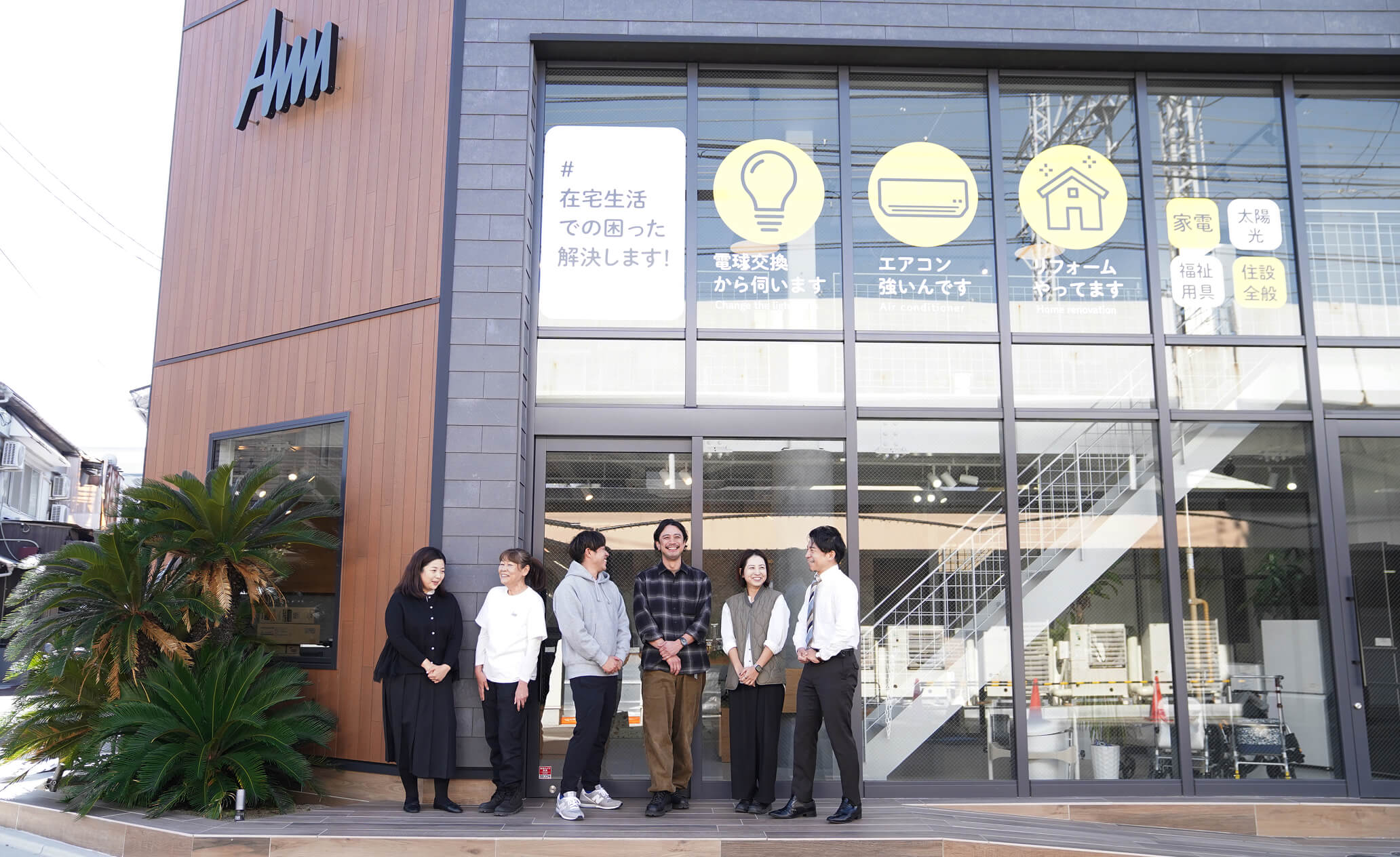 お店の前で立つスタッフ達の写真
