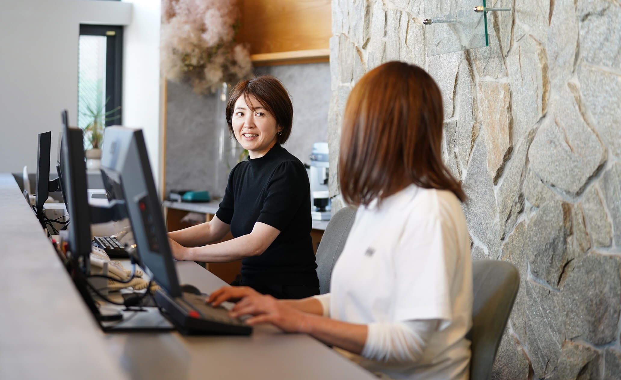 パソコンの前で話をするスタッフ達の写真