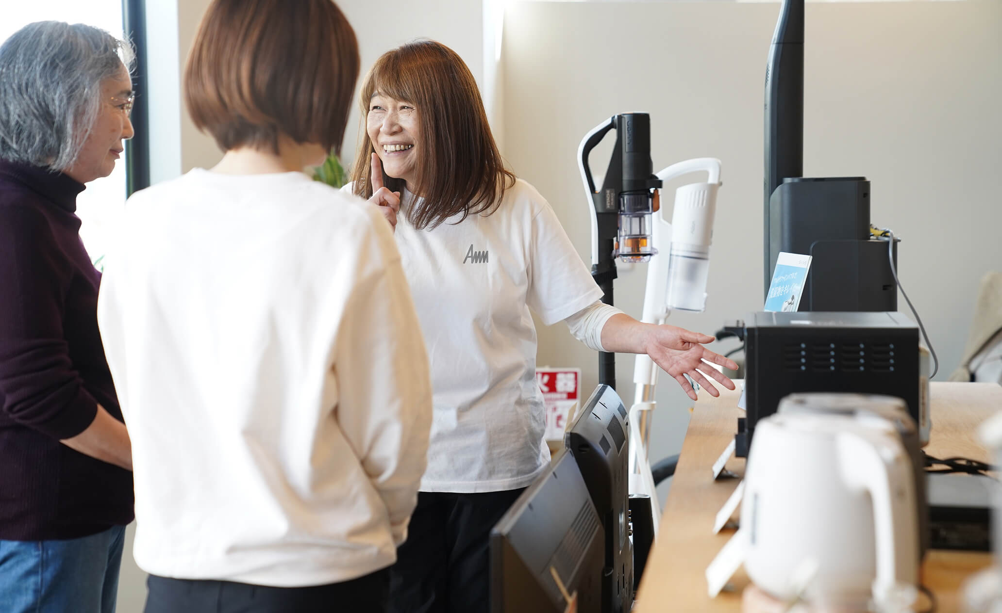 店内で家電の説明をするスタッフとお客様の写真
